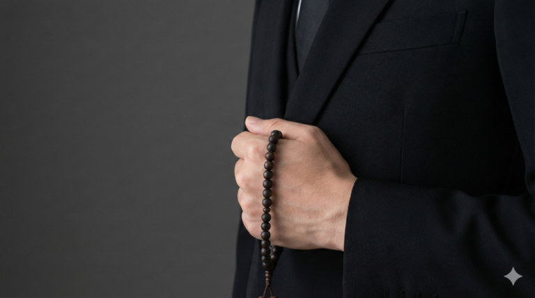 葬儀や通夜の参列マナーを示す、喪服姿で数珠を持つ男性の手元写真