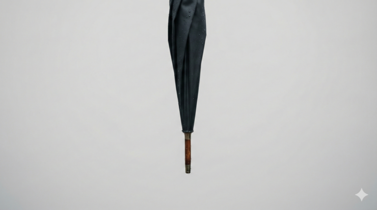 結婚式の雨の日マナーを伝えるアイキャッチ。水滴がついた落ち着いたデザインの高級傘のクローズアップ写真。